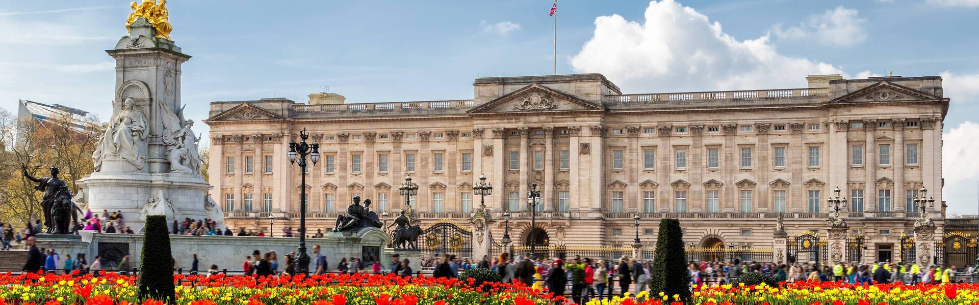 //d337pdvlg6sju5.cloudfront.net/media/buckingham_palace_frontage_with_red_and_yellow_flowers_401_1920x600.jpeg
